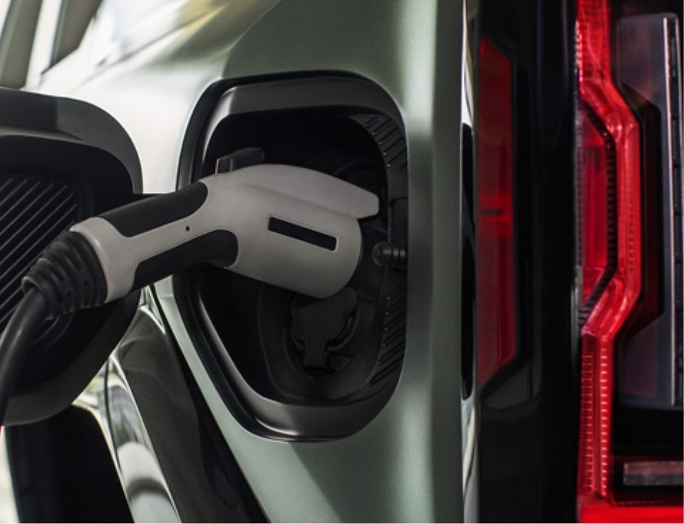 Close up of charging port with charger plugged in on a GMC Hummer EV SUV - Hall GMC in Canton TX